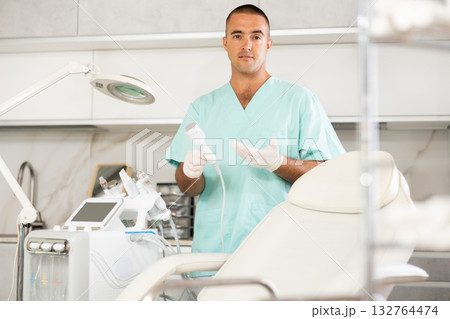 Male doctor invites you to visit a beauty clinic for facial skin rejuvenation using modern devices 132764474