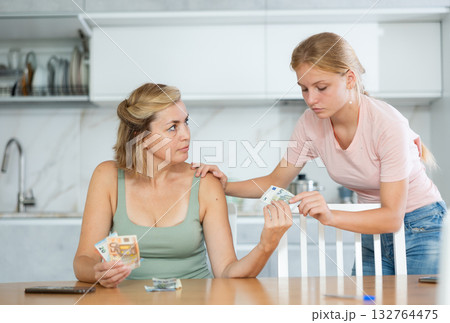 Woman received salary giving pocket money to teenage daughter Woman received salary giving pocket money to teenage daughter 132764475