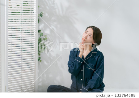 悩む表情のパジャマの女性 132764599