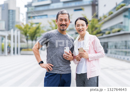ジョギング中にスマホを見る夫婦 132764643