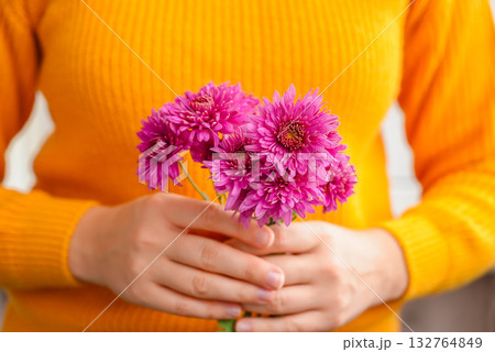 Woman showing into camera pink chrysanthemum Autumn garden colorful flowers. Beautiful autumnal bouquet dahlia chrysanthemum. Red pink orange fall color fall floral background. Flower shop and florist Woman showing into camera pink chrysanthemum Autumn garden colorful flowers. Beautiful autumnal bouquet dahlia chrysanthemum. Red pink orange fall color fall floral background. Flower shop and florist 132764849