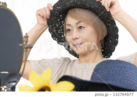 夏の外出で紫外線対策に帽子.サングラスを選ぶシニア女性 夏の外出で紫外線対策に帽子.サングラスを選ぶシニア女性 132764877