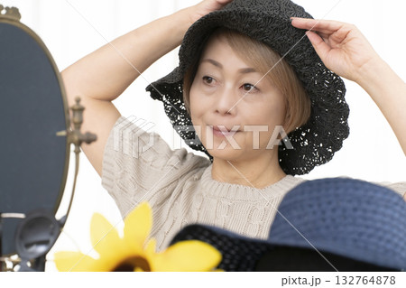 夏の外出で紫外線対策に帽子.サングラスを選ぶシニア女性 夏の外出で紫外線対策に帽子.サングラスを選ぶシニア女性 132764878