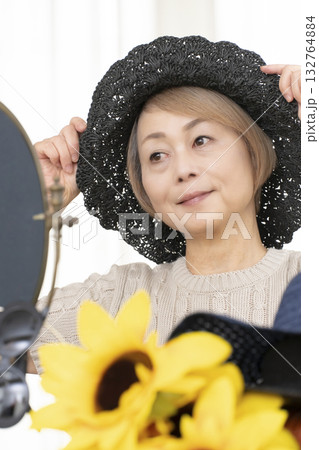 夏の外出で紫外線対策に帽子.サングラスを選ぶシニア女性 132764884