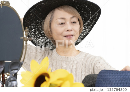 夏の外出で紫外線対策に帽子.サングラスを選ぶシニア女性 132764890