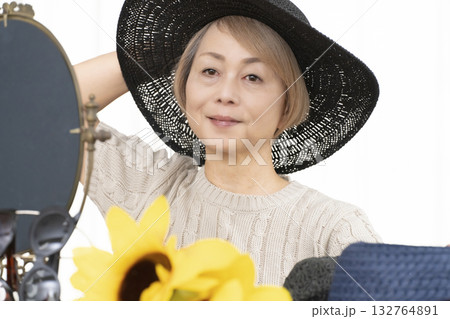 夏の外出で紫外線対策に帽子.サングラスを選ぶシニア女性 夏の外出で紫外線対策に帽子.サングラスを選ぶシニア女性 132764891