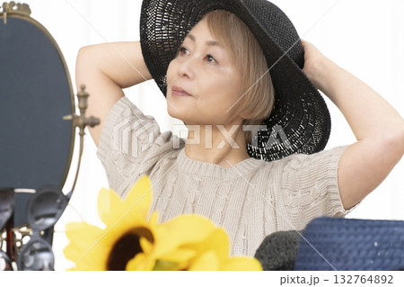 夏の外出で紫外線対策に帽子.サングラスを選ぶシニア女性 夏の外出で紫外線対策に帽子.サングラスを選ぶシニア女性 132764892