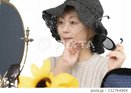 夏の外出で紫外線対策に帽子.サングラスを選ぶシニア女性 夏の外出で紫外線対策に帽子.サングラスを選ぶシニア女性 132764904