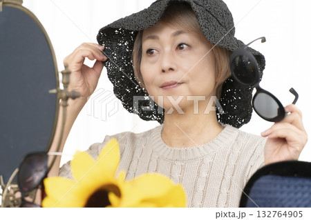 夏の外出で紫外線対策に帽子.サングラスを選ぶシニア女性 132764905