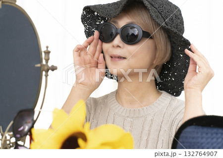 夏の外出で紫外線対策に帽子.サングラスを選ぶシニア女性 夏の外出で紫外線対策に帽子.サングラスを選ぶシニア女性 132764907