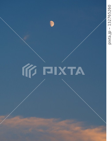 夕暮れの空に浮かぶ月と雲 132765260