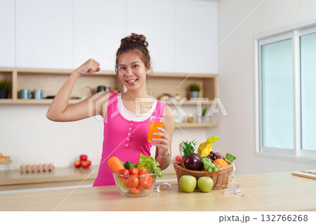 Empowered Health. Woman flexing muscles while enjoying a healthy drink. 132766268