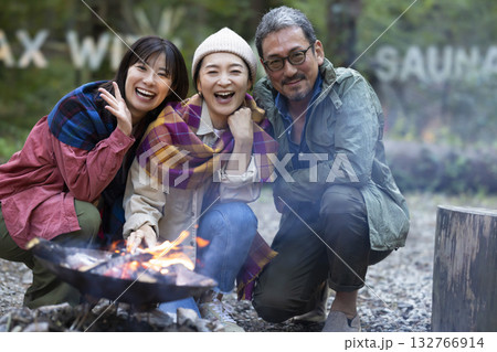 キャンプ場で焚き火をする家族 132766914