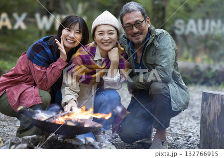 キャンプ場で焚き火をする家族 132766915