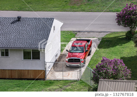 Driveway with red pick up truck parked next to the home. Driveway with red pick up truck parked next to the home. 132767818