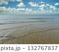 sea waves with sand and cloudy blue sky 132767837