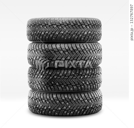Four studded winter tires are stacked neatly in preparation for installation. These tires provide traction and safety on icy surfaces during the winter season. Four studded winter tires are stacked neatly in preparation for installation. These tires provide traction and safety on icy surfaces during the winter season. 132767897