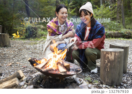 キャンプ場で焚き火をする家族 132767910