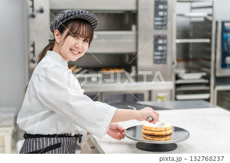 菓子工房,ケーキ屋の厨房,ベーカリーで働くコックコート姿の若いアジア人女性（パティシエ） 132768237