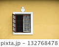 Open window with iron bars in a yellow traditional European style house 132768478