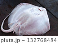 A freshly caught stingray lies on a wooden tabletop at a fish market. 132768484