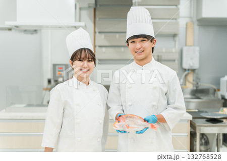 魚を調理するコックコート姿の男女スタッフ（料理人・生鮮市場・食品加工） 132768528
