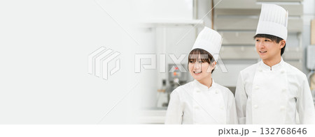 厨房・キッチンに立つコックコート姿の調理師・シェフ・コックの男女 厨房・キッチンに立つコックコート姿の調理師・シェフ・コックの男女 132768646