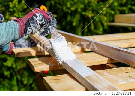 Painting Wood Planks with White Paint for Outdoor DIY Project. Skilled Craftsmanship 132768711