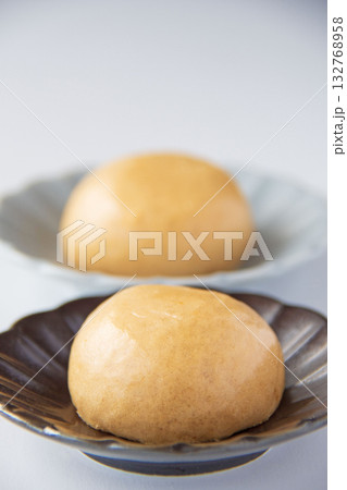 皿にのせた温泉まんじゅう 132768958