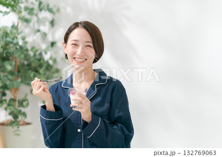 デザートを食べるパジャマの女性 132769063