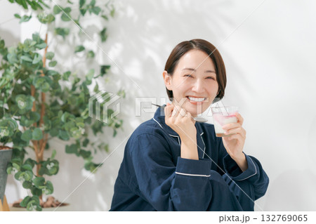 デザートを食べるパジャマの女性 132769065