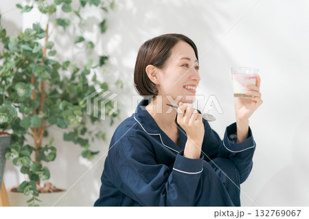 デザートを食べるパジャマの女性 132769067
