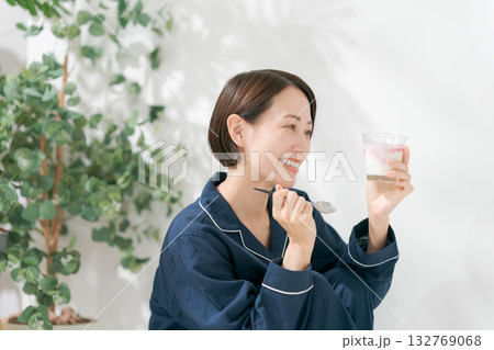 デザートを食べるパジャマの女性 132769068