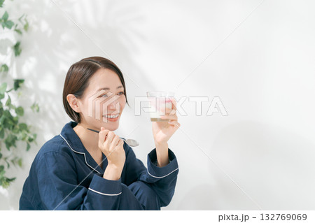 デザートを食べるパジャマの女性 132769069