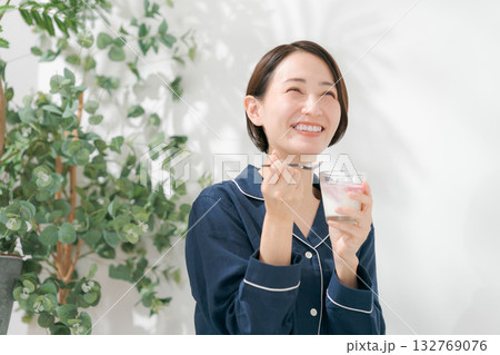 デザートを食べるパジャマの女性 132769076