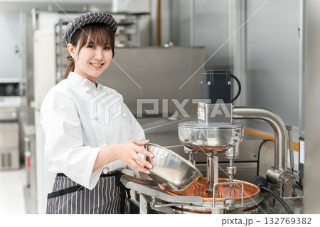 厨房でミキサーを使うパティシエの女性スタッフ 132769382