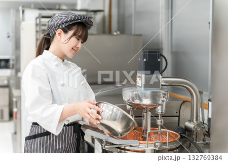 厨房でミキサーを使うパティシエの女性スタッフ 厨房でミキサーを使うパティシエの女性スタッフ 132769384