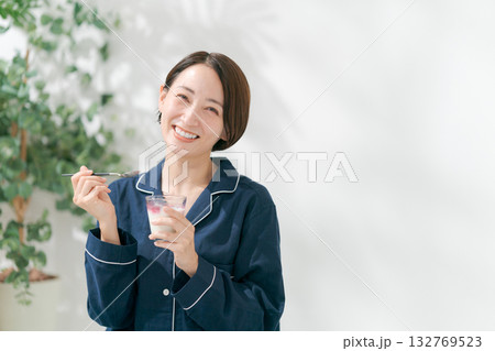 デザートを食べるパジャマの女性 132769523