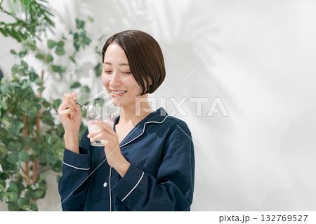 デザートを食べるパジャマの女性 132769527