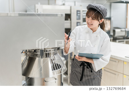 厨房機器を点検,チェックする厨房スタッフの女性 132769684