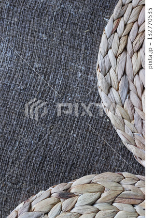 Two placemats made of water hyacinth on rough linen burlap. 132770535