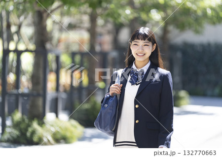 スクールバッグを肩にかけて歩く笑顔の女子高校生　 132770663