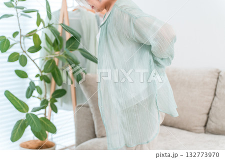リビングのソファーで腰を痛がるシニア女性 132773970