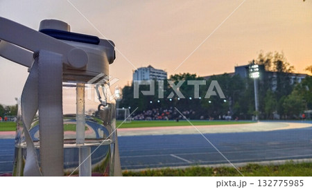 A water bottle with a black background and a blue running track 132775985