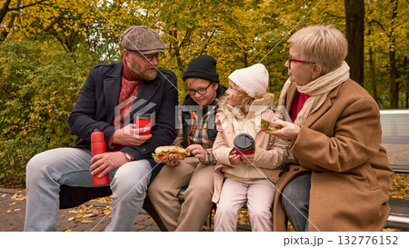 Autumn family conversation with coffee and sandwiches in park Autumn family conversation with coffee and sandwiches in park 132776152