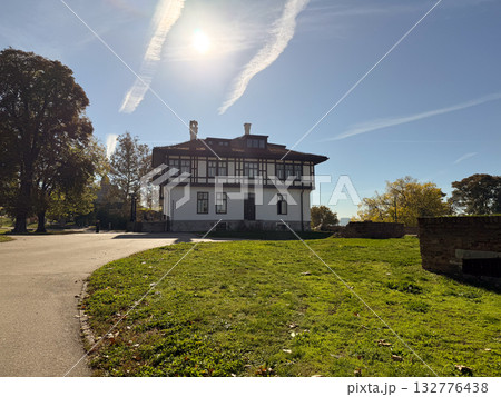 Historic building surrounded by trees and sunlight in city park. Architecture, heritage and the tranquil atmosphere of autumn day. Historic building surrounded by trees and sunlight in city park. Architecture, heritage and the tranquil atmosphere of autumn day. 132776438