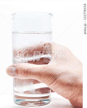 Hand holding a glass of water on a white background Hand holding a glass of water on a white background 132776559