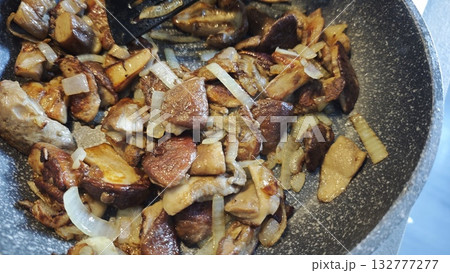 Sauteed wild mushrooms with onions in a pan, cooked to golden brown perfection. Concept of rustic homemade cooking and seasonal forest harvest 132777277