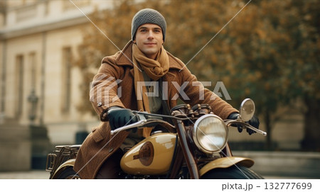 A vintage motorbike rider is happily enjoying an autumn setting on a scenic city street 132777699