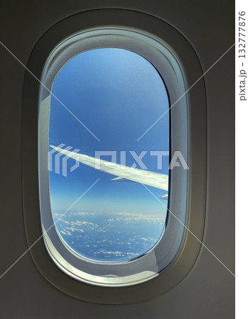 飛行機の窓から見た青空と翼 132777876